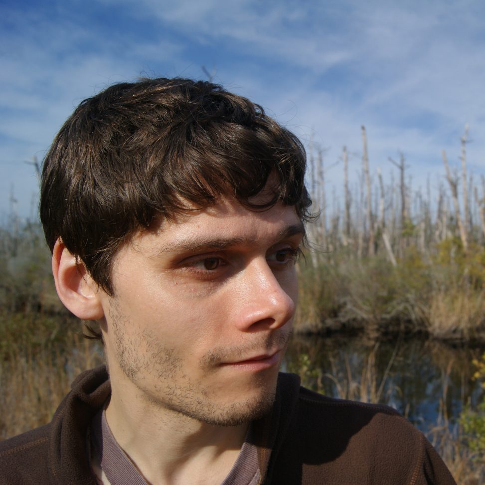 James Lendemer is a white man with short brown hair. He is standing in front of a small pond.