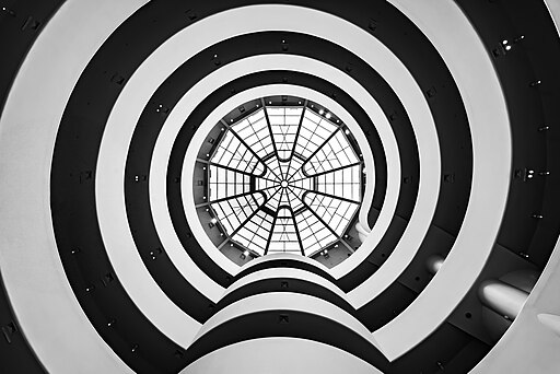 Interior photograph of the Guggenheim Museum in NYC, taken from the lobby looking upwards at the walkway spirals and skylight