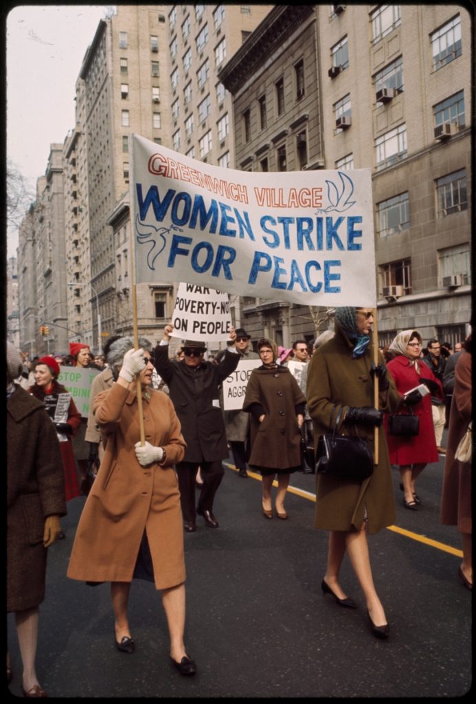 Women holding sign saying "women strike for peace" at anti-war rally