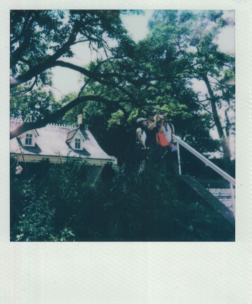 Polaroid photo of three people standing at the top of an outdoor staircase