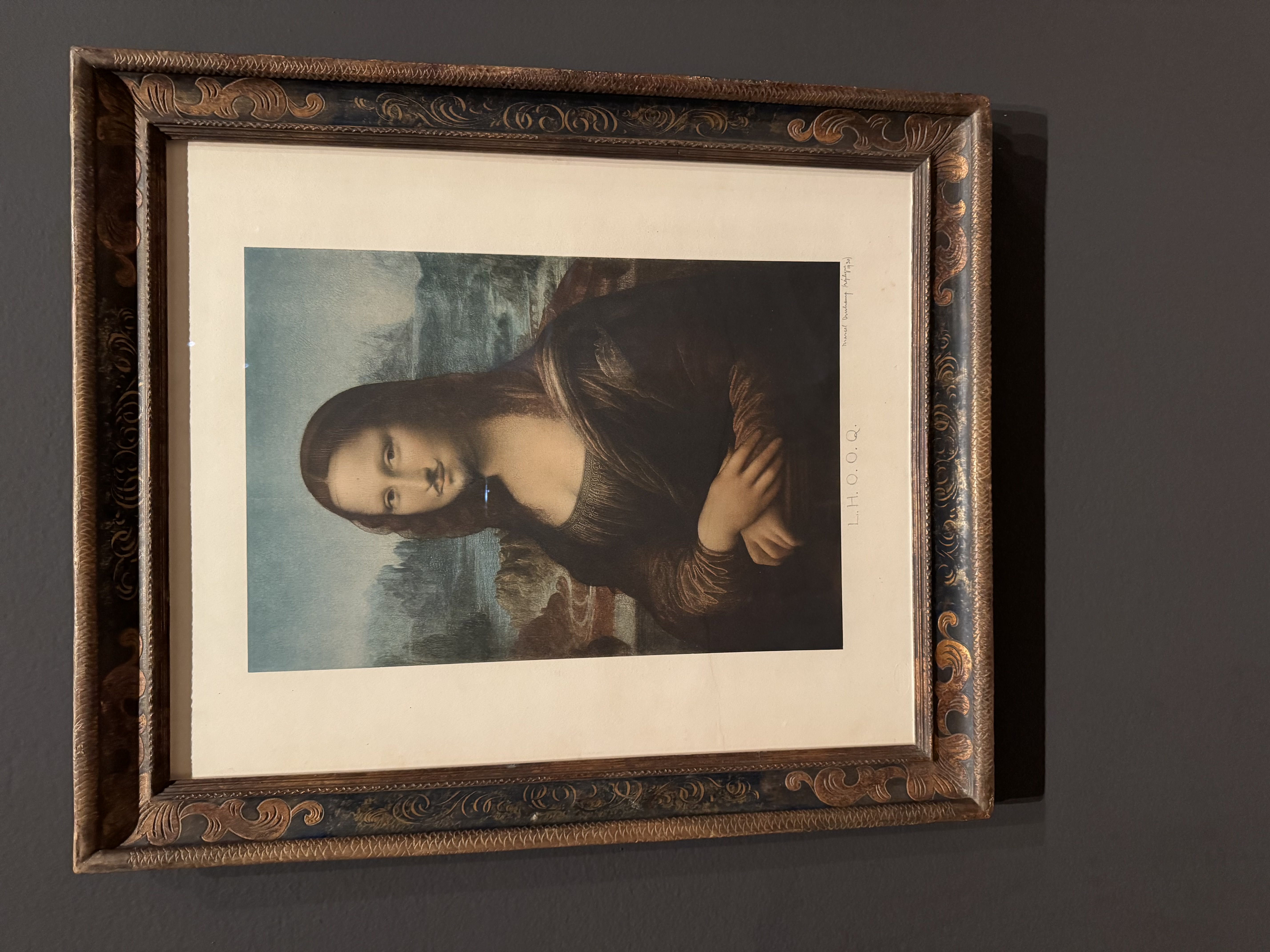 Marcel Duchamp's L.H.O.O.Q. 1930 at MoMA: a print of the Mona Lisa with a hand drawn mustache and goatee penciled onto her face.