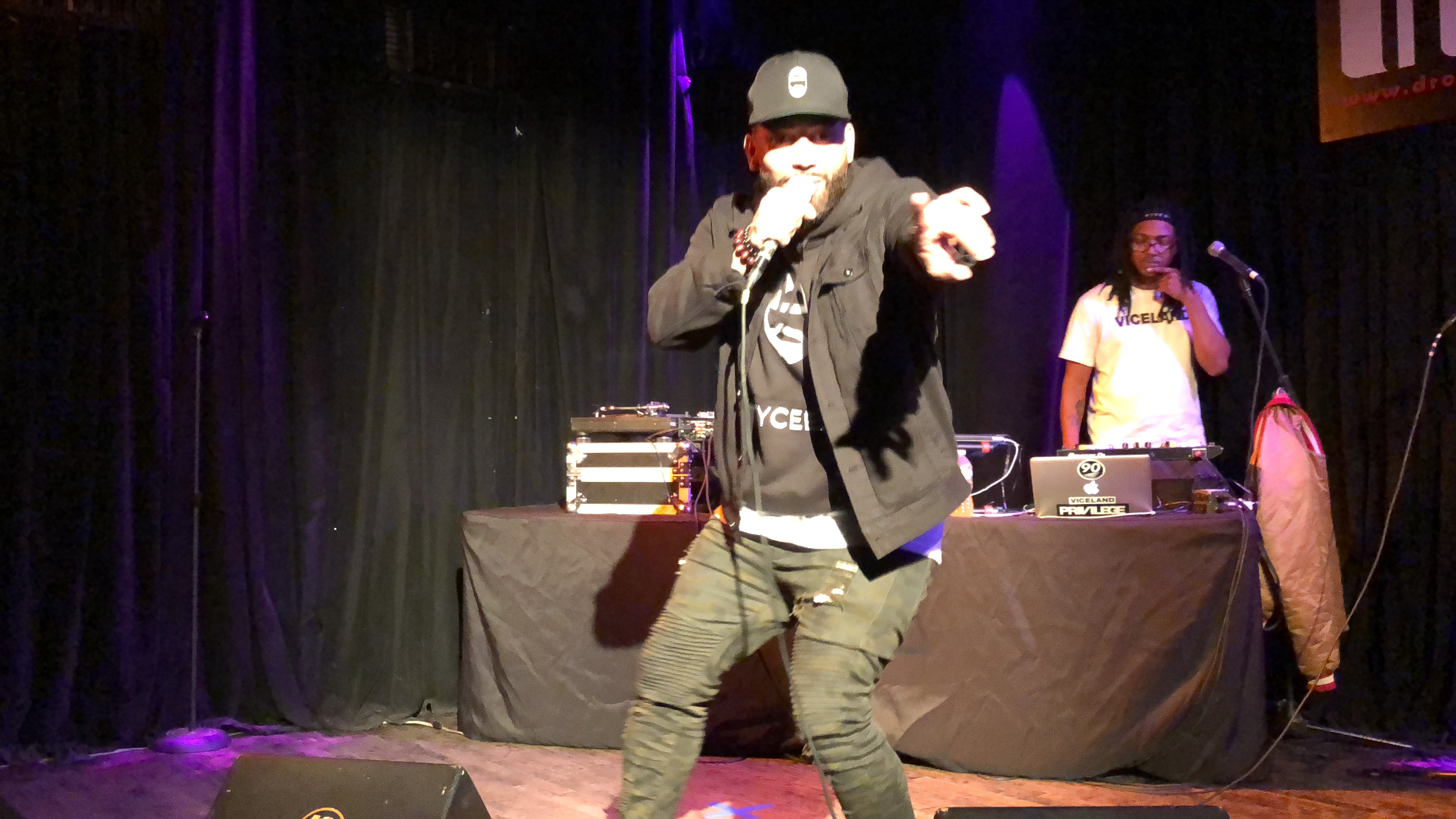 NYCEEJ pointing into the crowd while rapping into the microphone