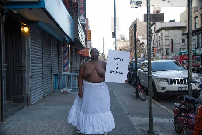 Image of artist Nona Faustine nude in front of Sojourner Truth’s Home on Canal Street