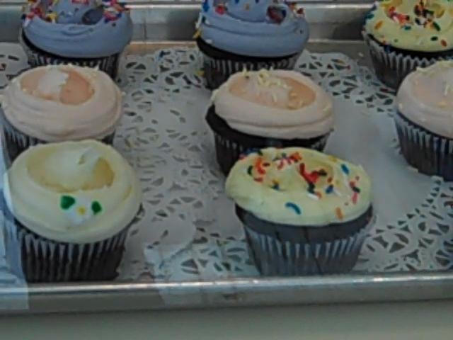 rows of cupcakes with varied color icing and bright sprinkles