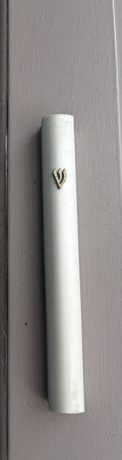 a mezuzah holds a sacred Jewish prayer and is carefully attached to my doorpost